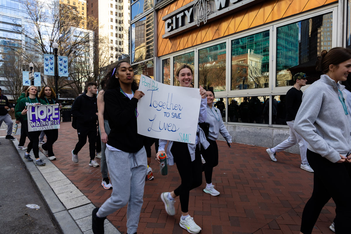 Students walk and carry signs.