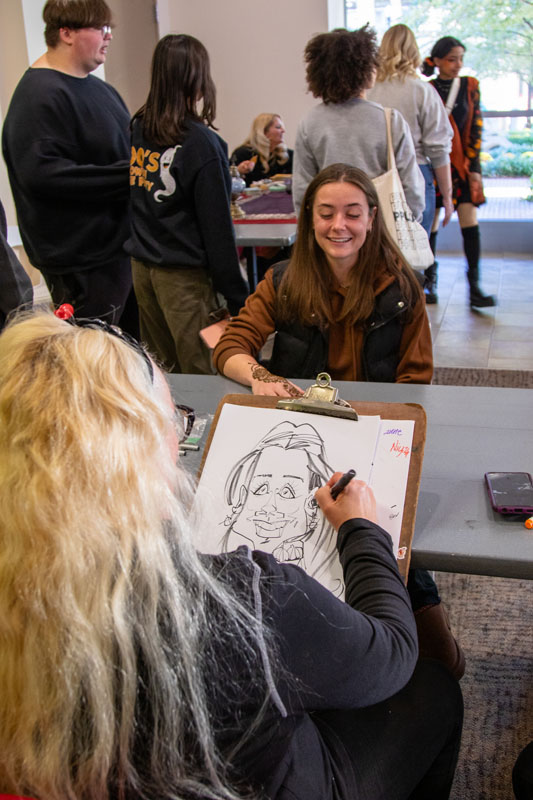 A student gets a caricature drawn.