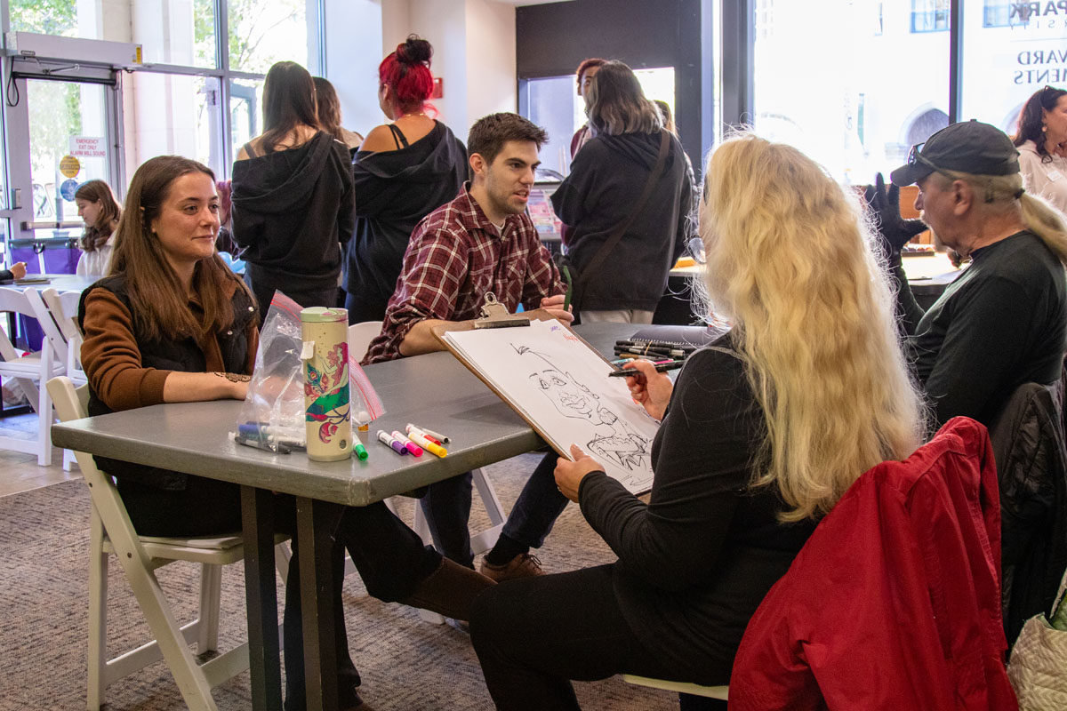 A student gets a caricature drawn. 