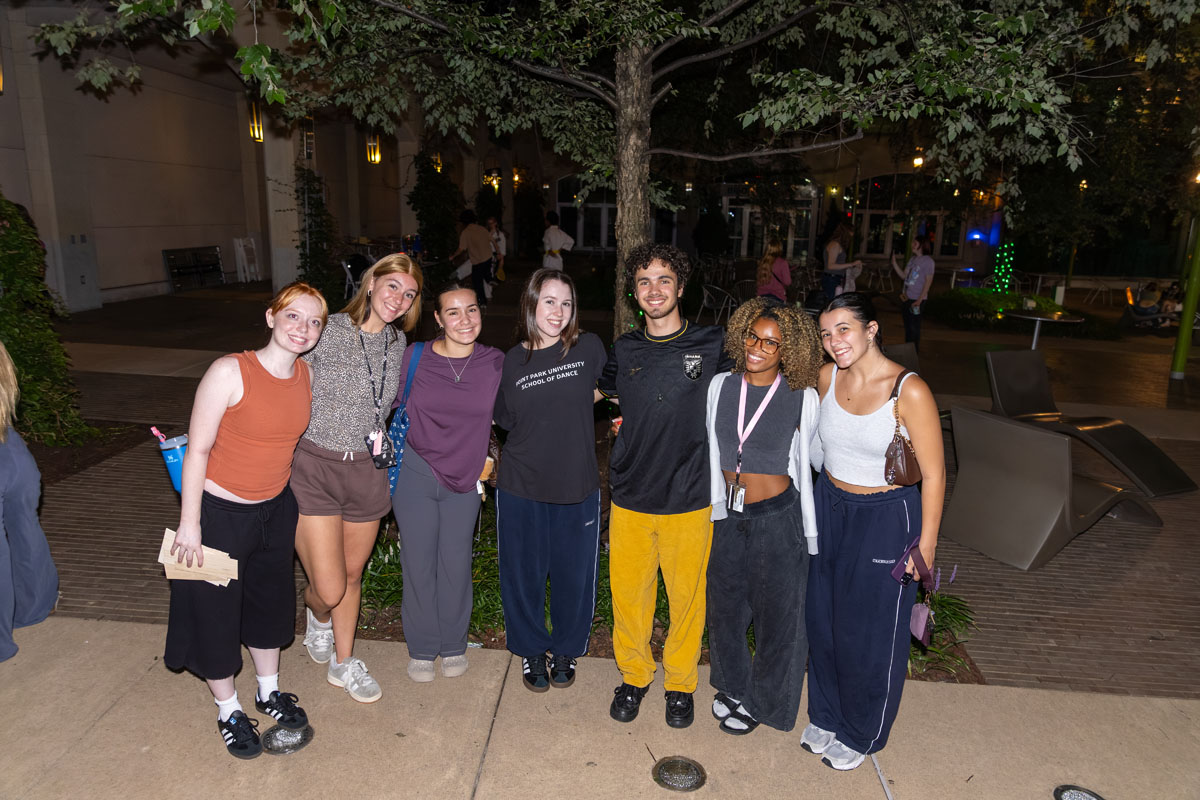 Students stand in a line in Village Park 