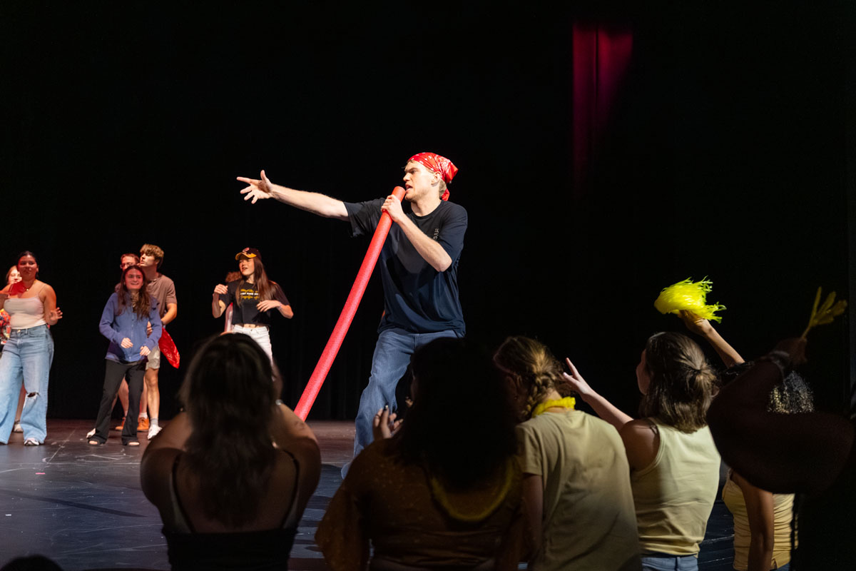 Students perform a lip sync on the stage. 