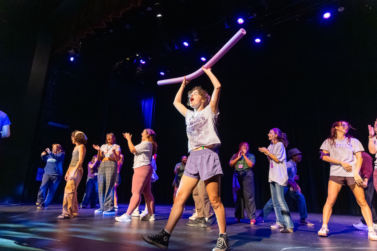 Students perform a lip sync on the stage. 