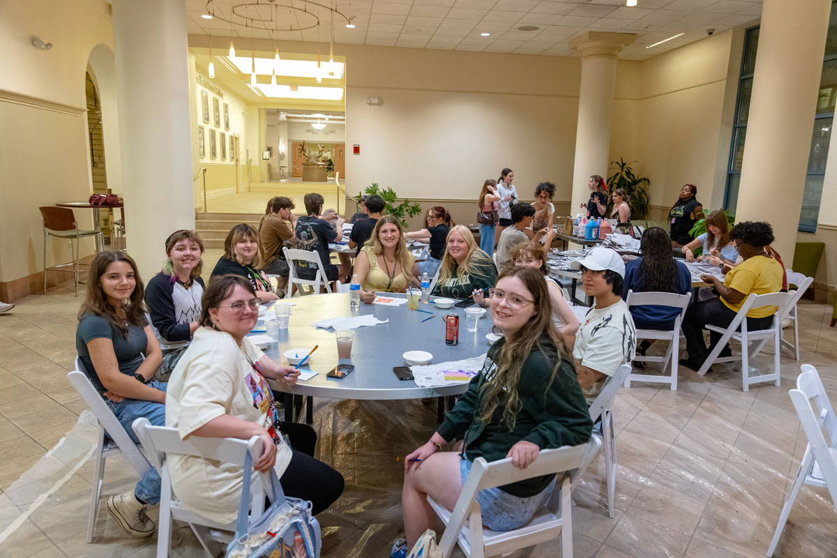 Students sit around tables doing an activity in Lawrence Hall Lobby.