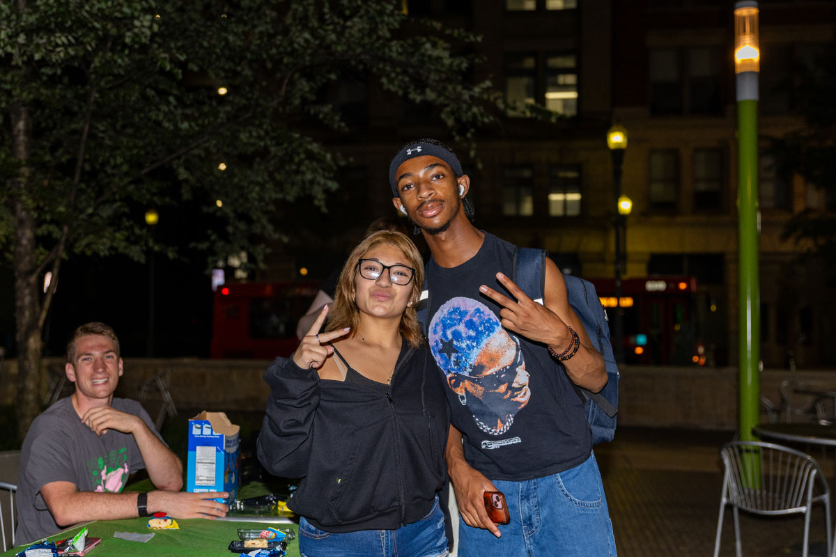 Two students pose at night in Village Park. 