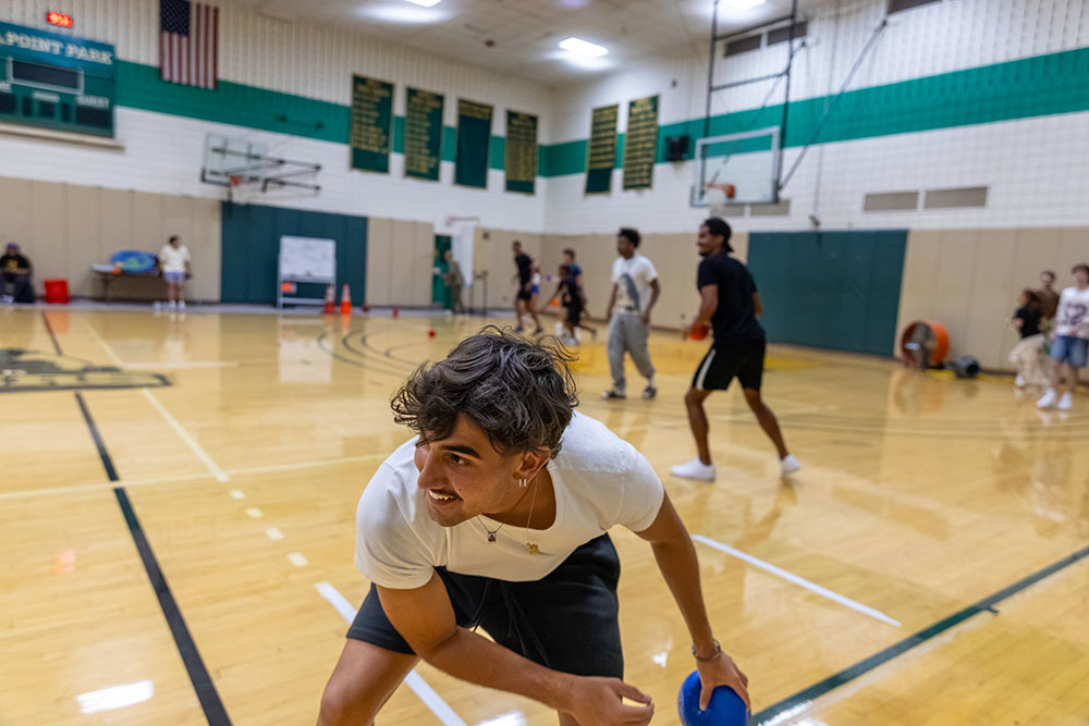 A student plays dodgeball in the gym.