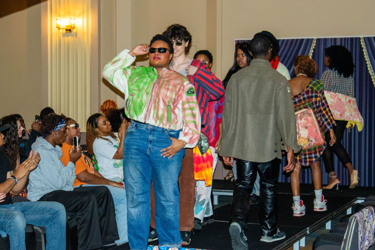 A line of students parade down the catwalk.