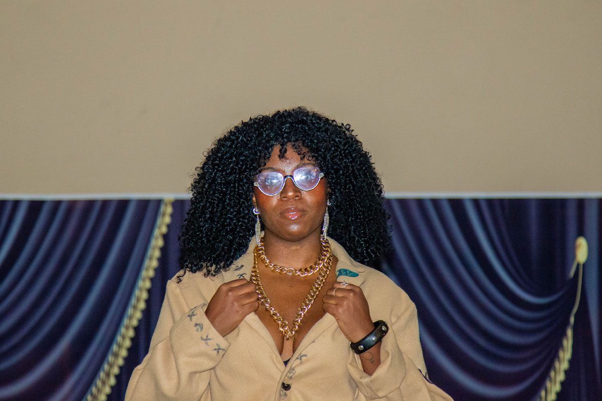 A woman walks down the catwalk in a tan outfit.