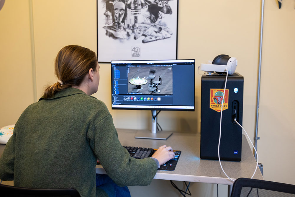 A female student designs a game on a computer.