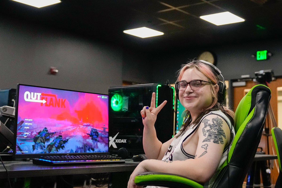 An esports player makes the peace sign. 