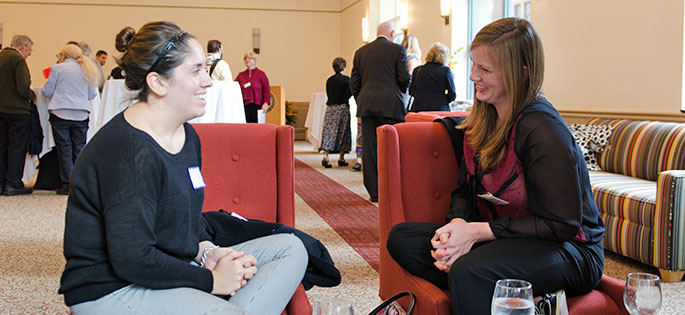 Two students who began graduate studies at Point Park fall 2014 share a conversation at a reception welcome the new master's and Ed.D. students in Lawrence Hall. | Photo by StartPoint Media