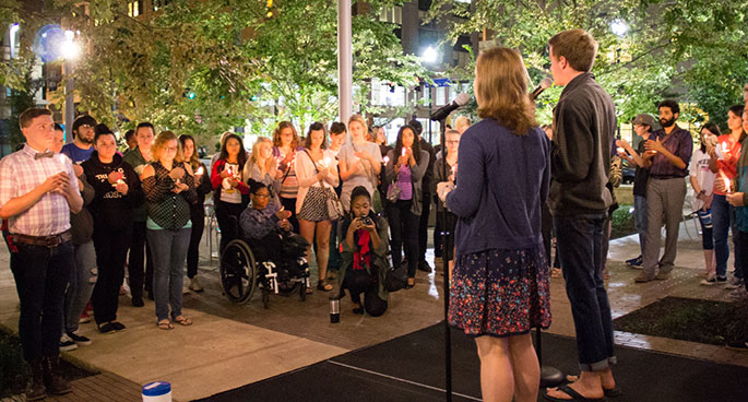 Point Park students hold lit candles while listening to singers during a vigil commemorating the 13th anniversary of the 9/11 terrorist attacks. The vigil was held in Point Park's Village Park. | Photo by Victoria A. Mikula