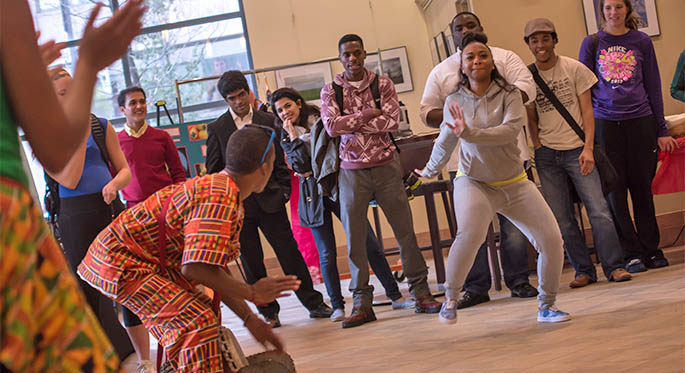 A female Point Park student steps out to try African dance accompanied by a drummer from the Legacy Arts Project African dance troupe at the 6th Annual Cultural Summit Oct. 15 in Lawrence Hall. | Photo by Christopher Squier