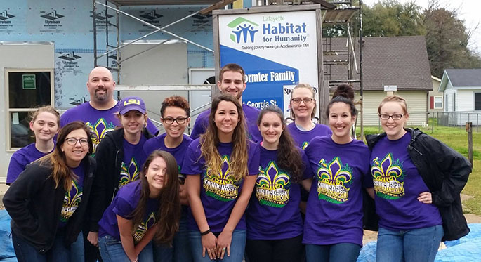 A group of Point Park students pose for a group shot at the Habitat for Humanity work site outside New Orleans, La., where they volunteered their time during spring break, 2015. 
