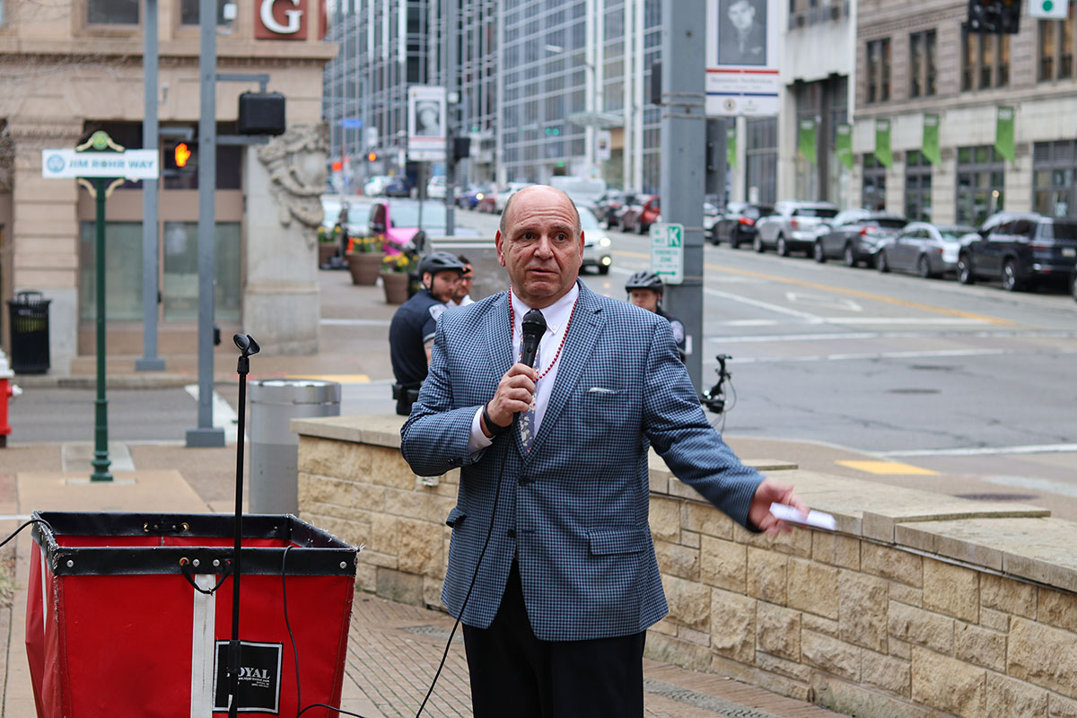 A man speaks into a microphone in Village Park.