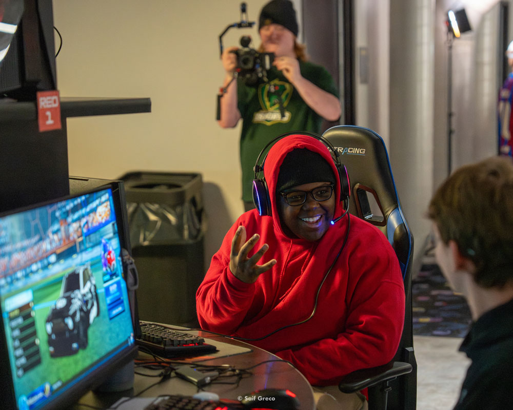 A high school esports athlete gestures in excitement.