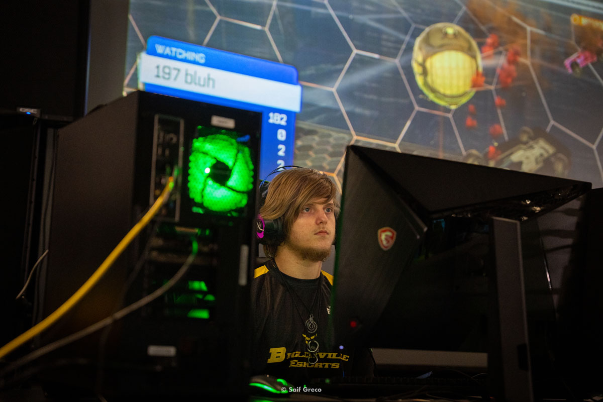 A high school esports athlete looks at their monitor intently.
