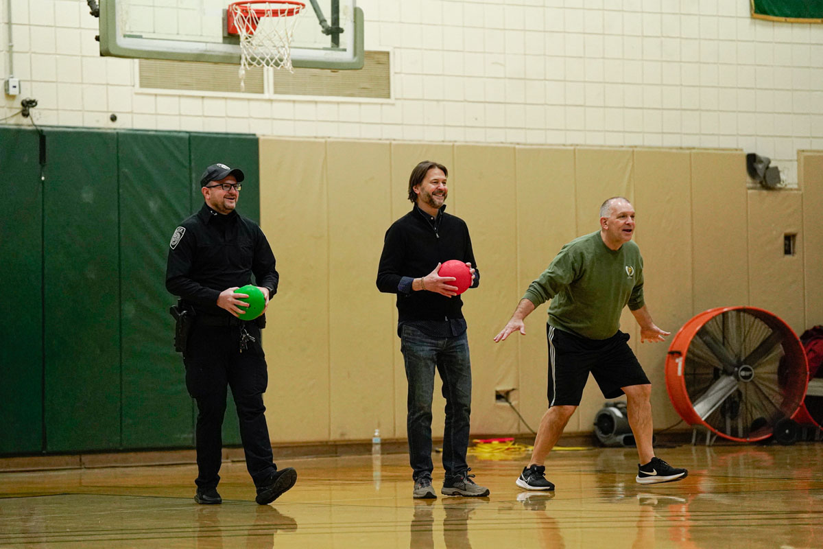 Police and staff members play dodgeball.