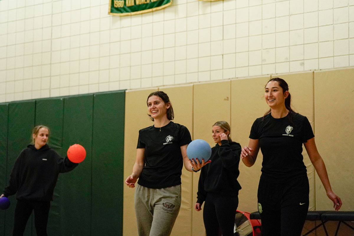 Female students play dodgeball.
