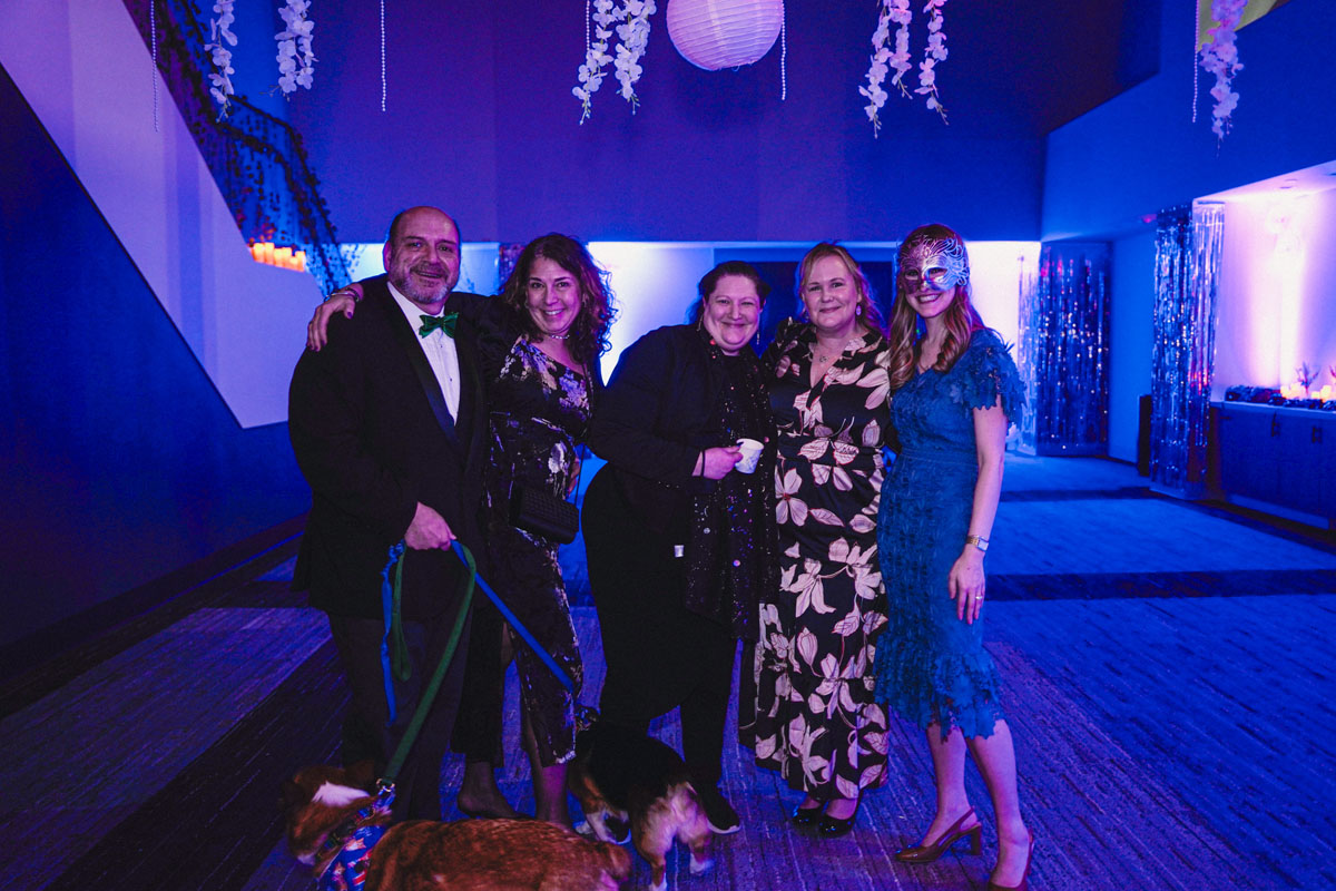Five staff members and two dogs pose at the prom.