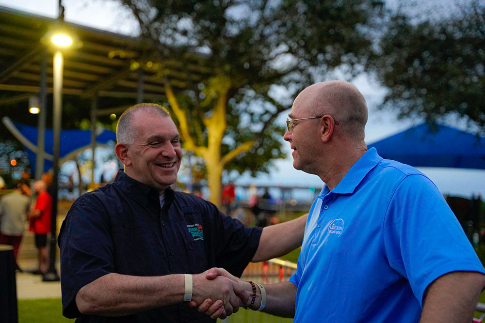 Two men shake hands.