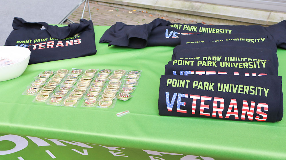 A table holds Point Park Veteran shirts and pins.