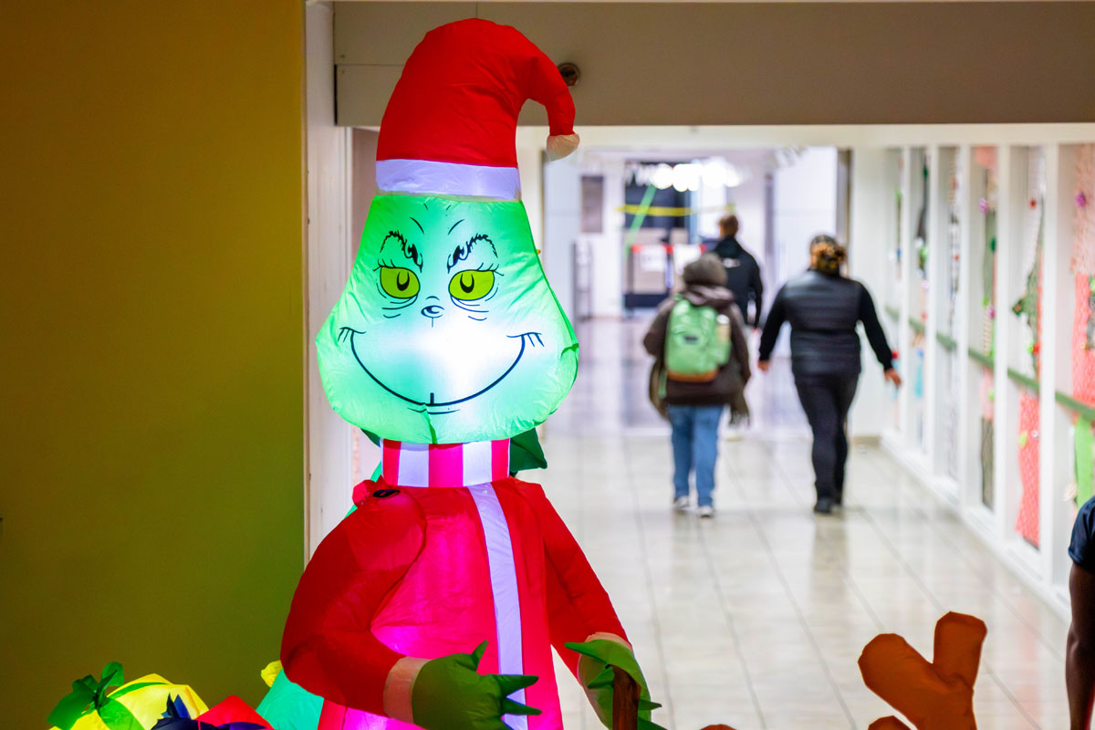 An inflatable Grinch with students in the background.
