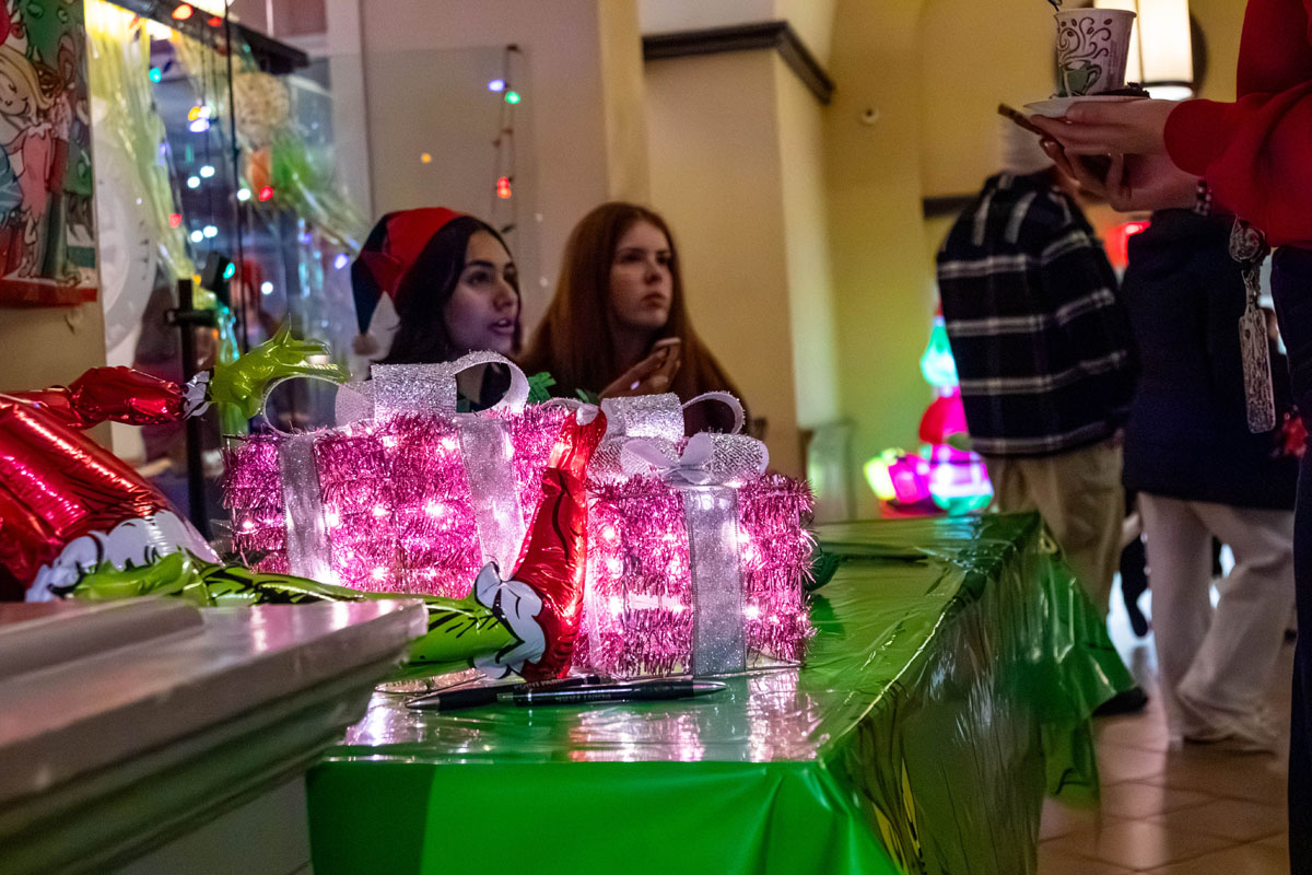 Students at a table decorated with Christmas lights.