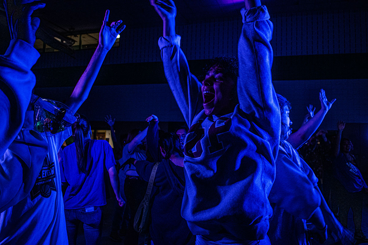 Students dance in a dark room. 