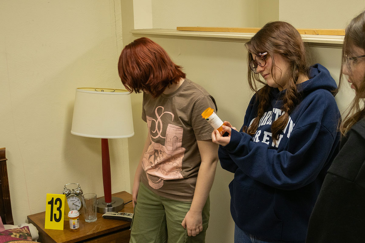 Students look at evidence in the CSI House.