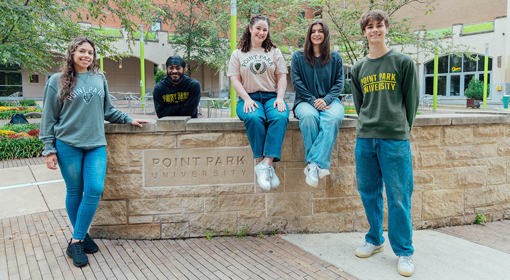 Students in Village Park next to a Point Park sign. Photo | Ethan Stoner