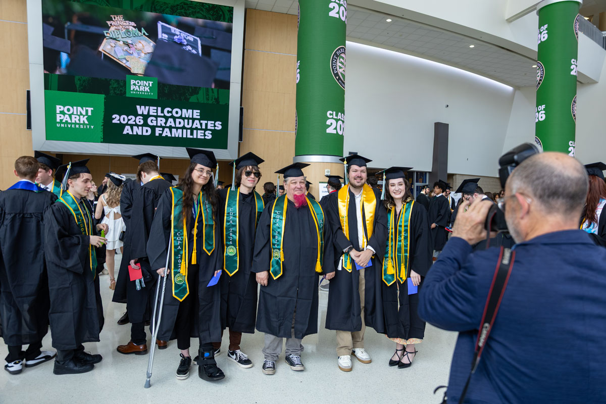 Graduates pose for a photo outside of the arena.