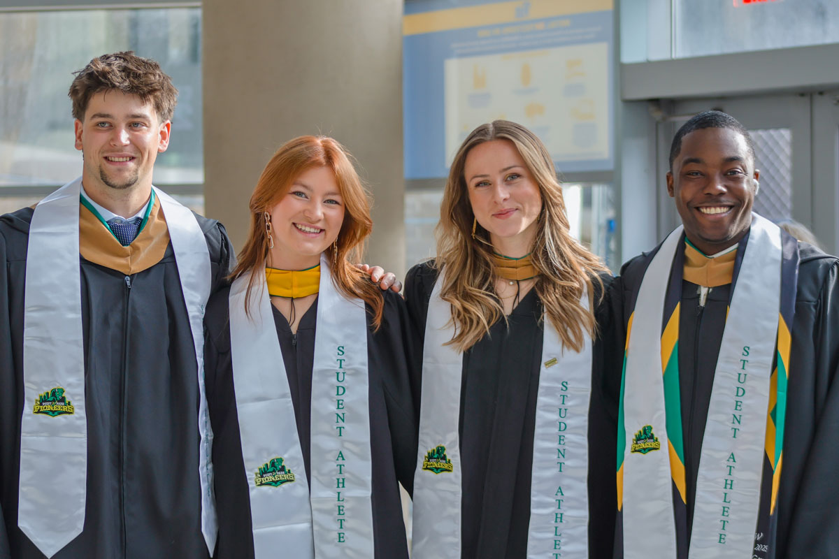 Four student athletes pose for a photo.