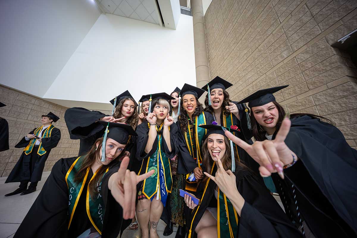 A group of graduates pose.