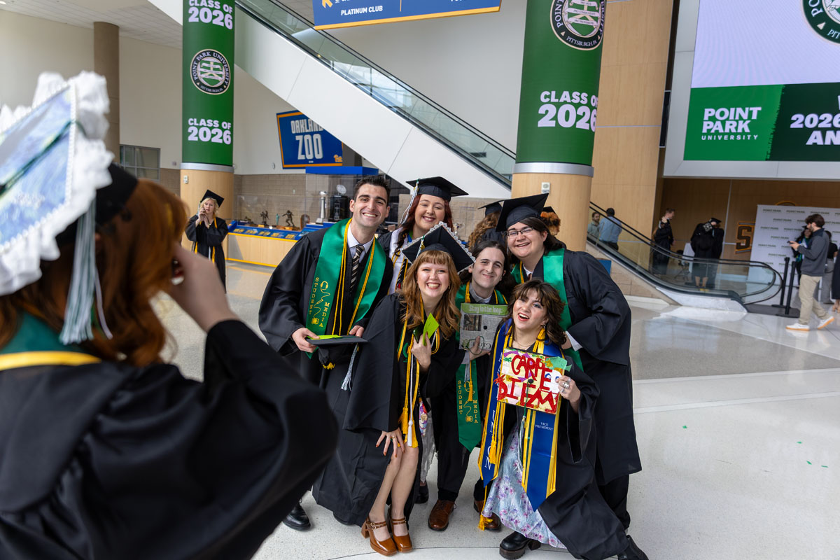 Graduates pose for a photo with friends.