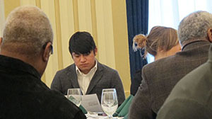 Male student reads program at MLK luncheon