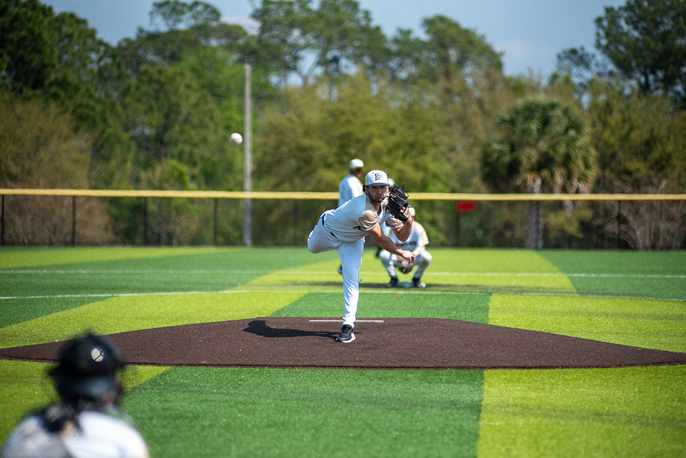 Pioneer men's baseball pitcher pitches a ball.