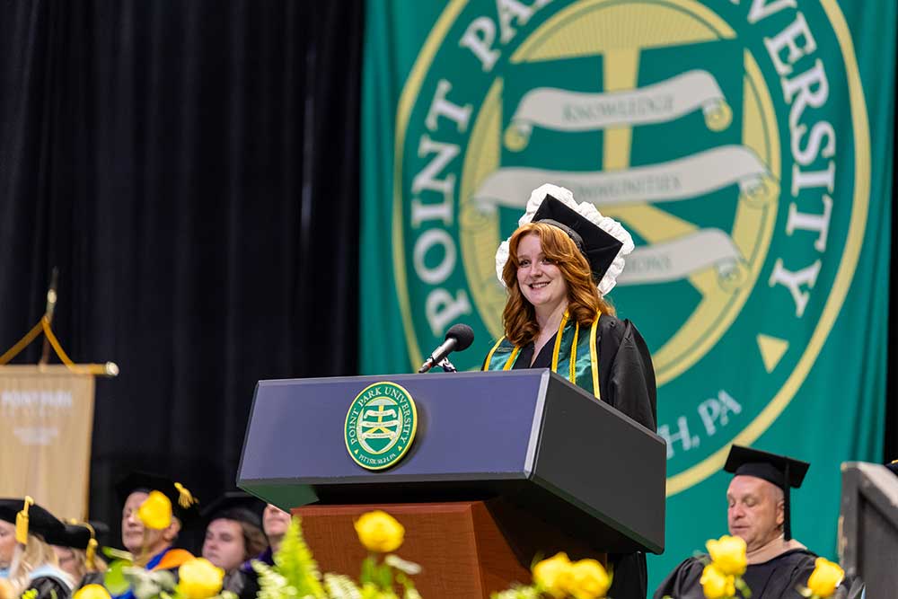 Devin Amigh speaks from a podium.