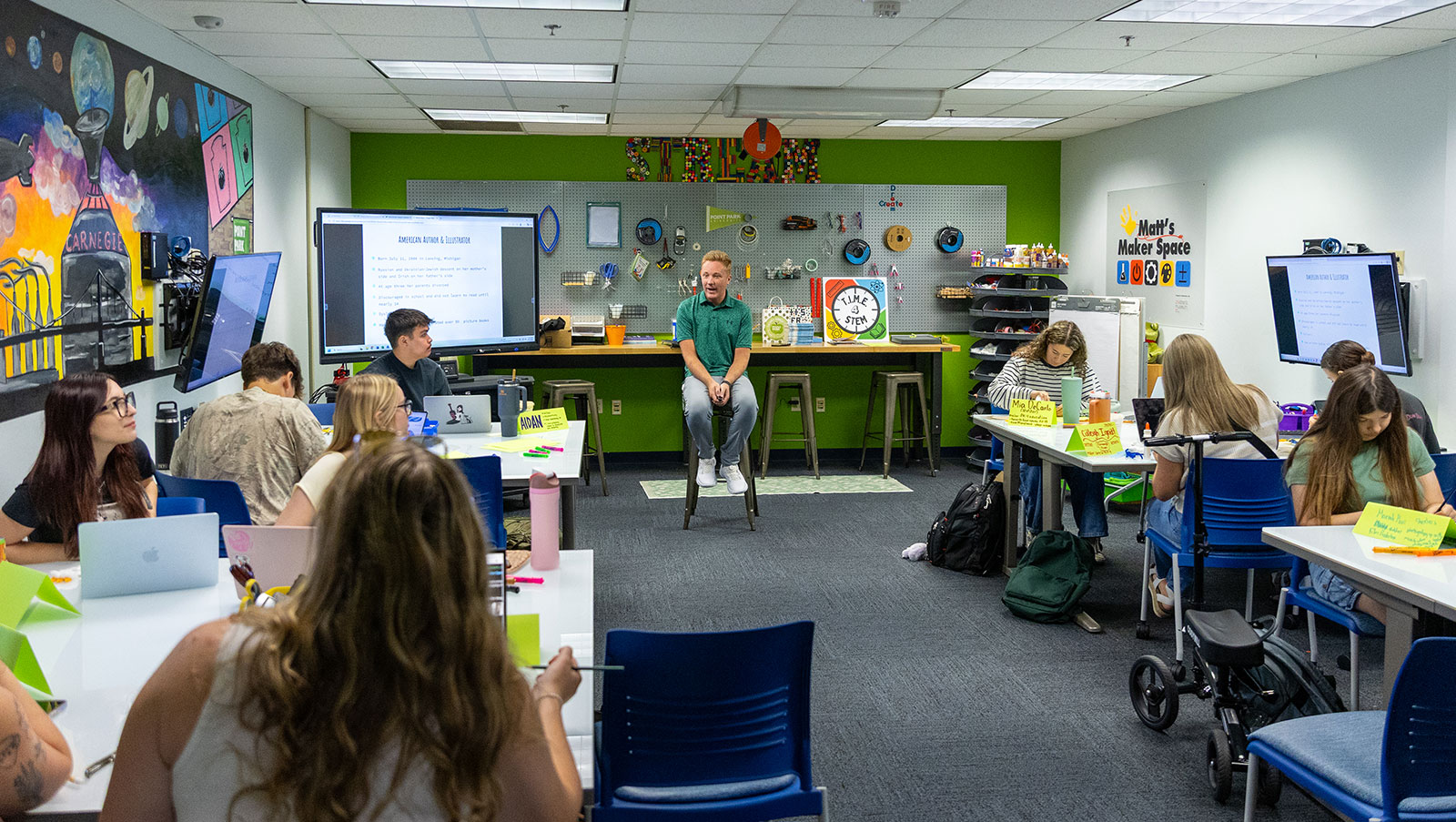 Pictured is Josh Sektnan sitting on a stool at the front of the Maker Space classroom.