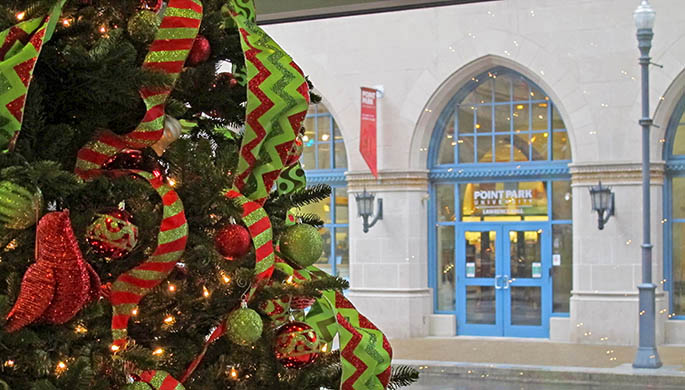 A decorated holiday tree stands in the lobby of Academic Hall, overlooking the arched doorways of Lawrence Hall across Wood Street.