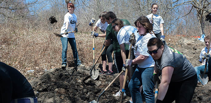 Students use shovels to cleanup a hillside as part of Pioneer Community Day 2014. | Photo by Christopher Rolinson