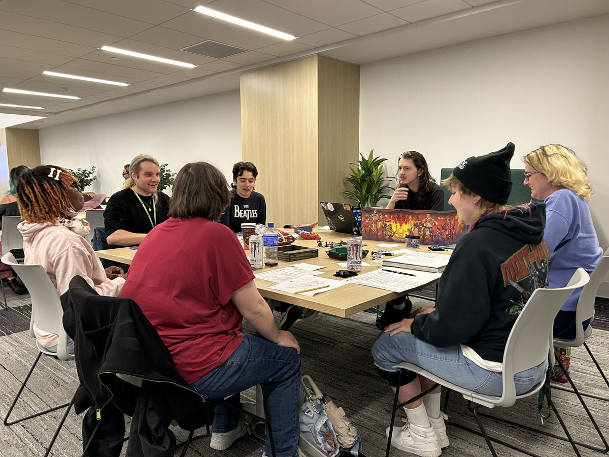 Students sit around a table playing Dungeons & Dragons in the Professional Career Readiness Center.