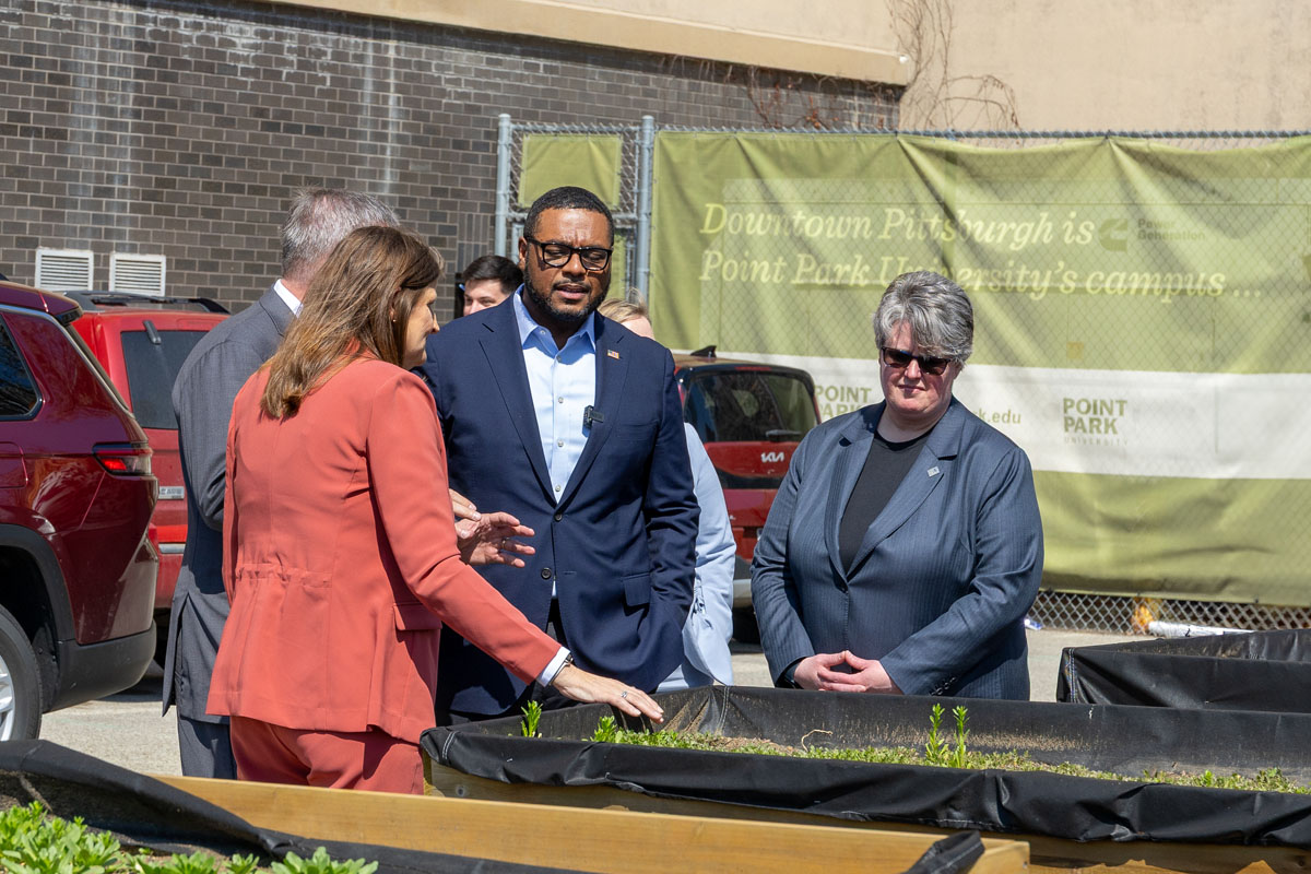 Heather Fiedler, Austin Davis and Carrie Rowe look at the community garden beds.
