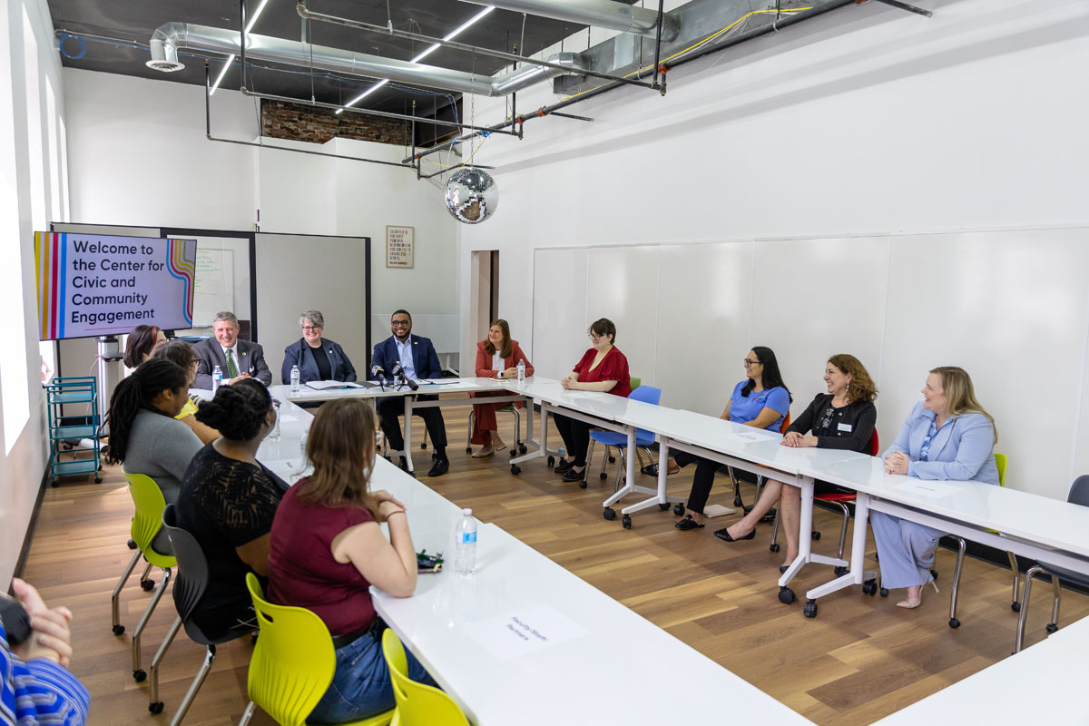 Tables in a square are filled with staff, students and visitors to discuss hunger on campus.