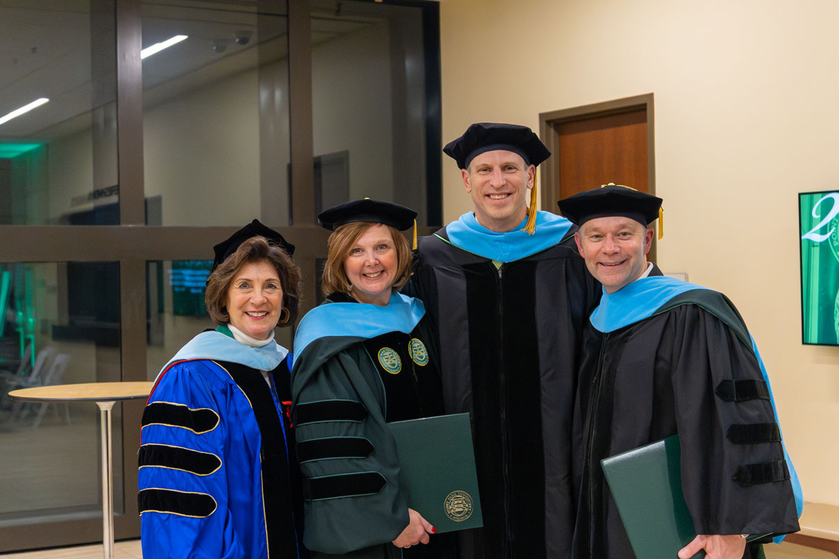 Education graduates pose with Dr. Linda Hippert.