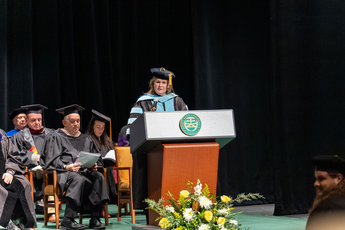Provost Shari Payne speaks from the stage at Hooding.