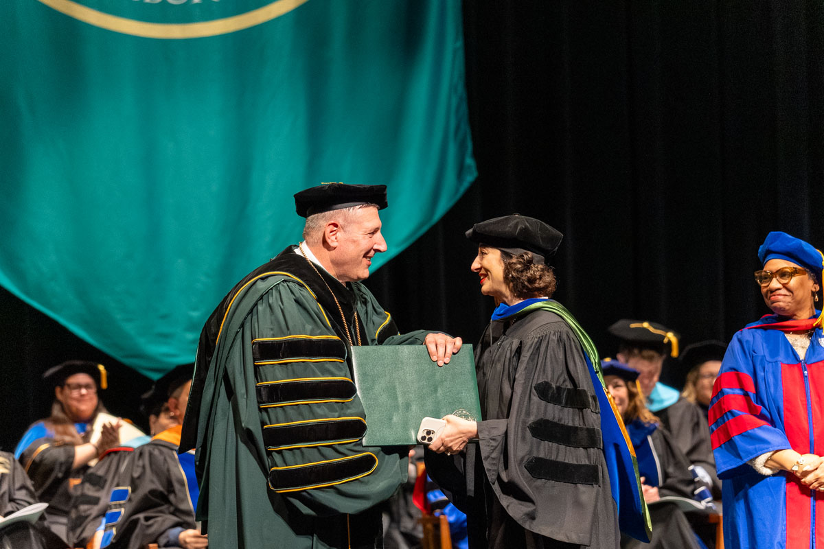 A student shakes Dr. Brussalis hand.