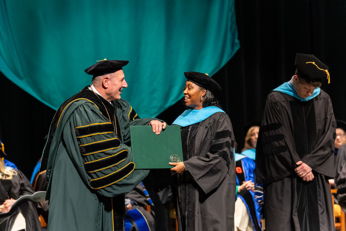A student shakes Dr. Brussalis' hand.