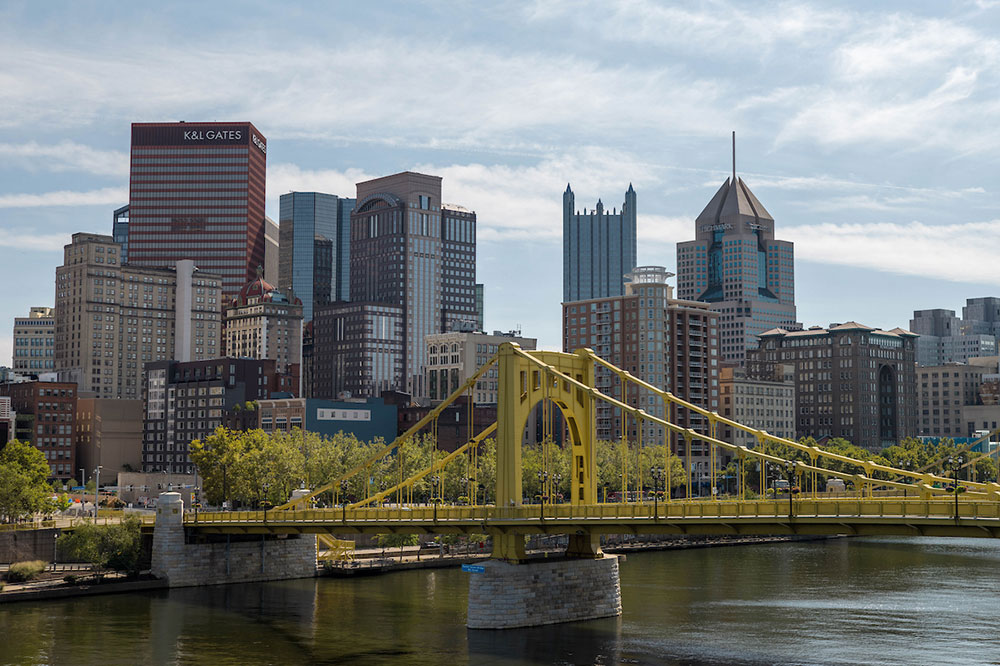 A city skyline view with a yellow bridge in the foreground.