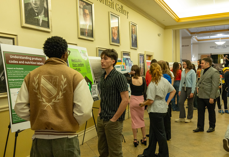 Students discuss their research projects at the Fall Forum in December 2025. 