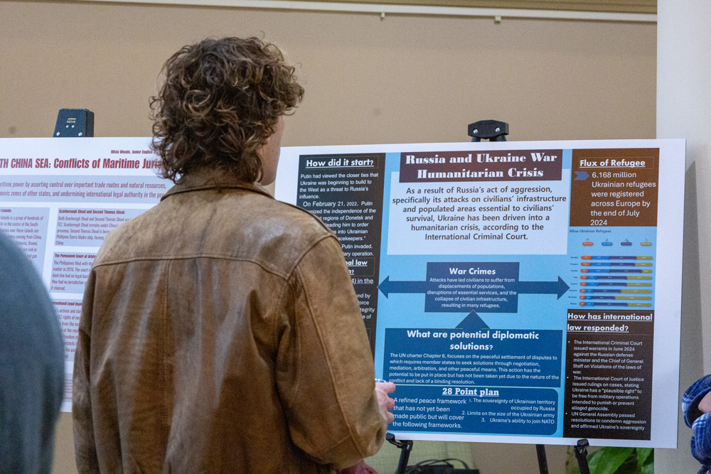 Students discuss their research projects at the Fall Forum in December 2025. 